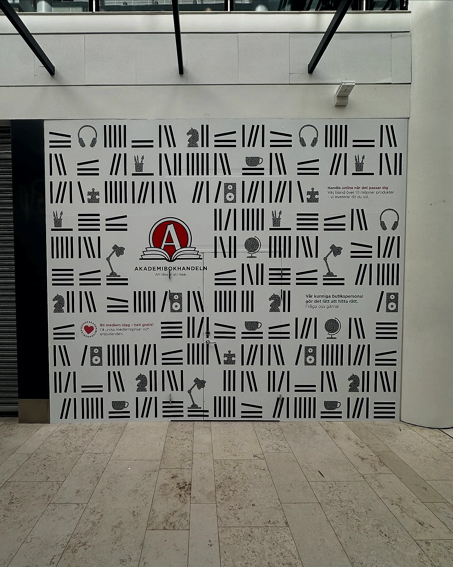 Large Akademibokhandeln mural with black illustrations on a commercial wall